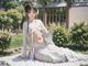 A woman in a white kimono sitting on the grass.