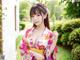 A woman in a pink and yellow kimono posing for the camera.